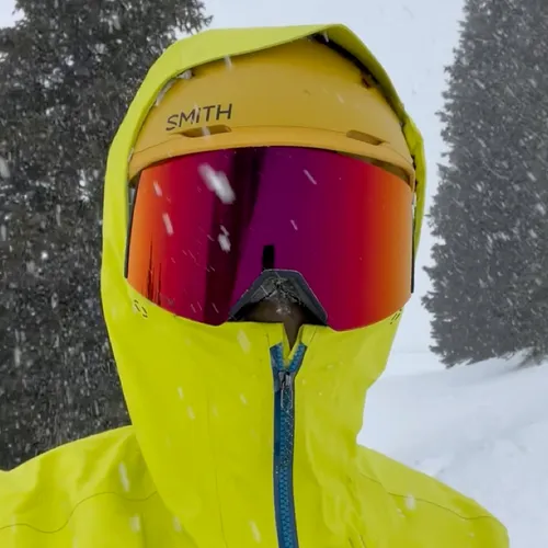 Amy in ski gear and goggles as snow falls around her